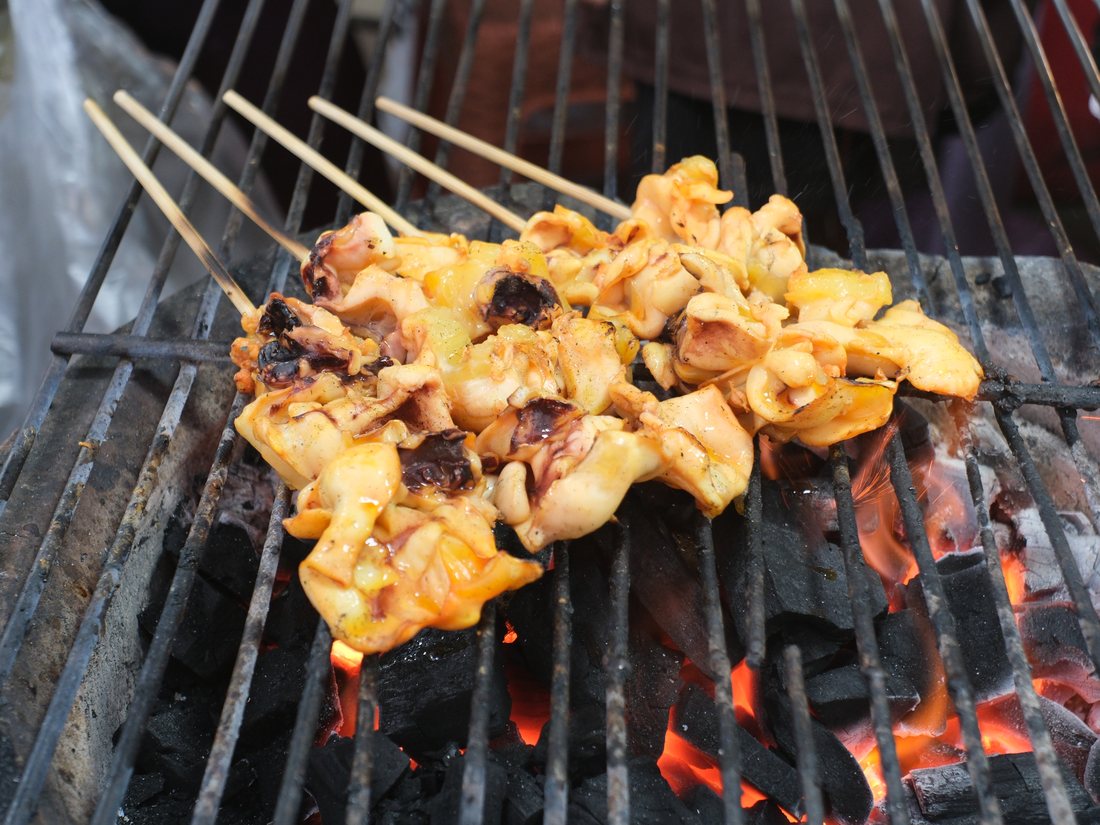 Skewers grilling over glowing charcoal
